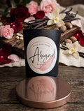 Candle labeled 'Abigail' with flowers and vanilla beans on a wooden surface