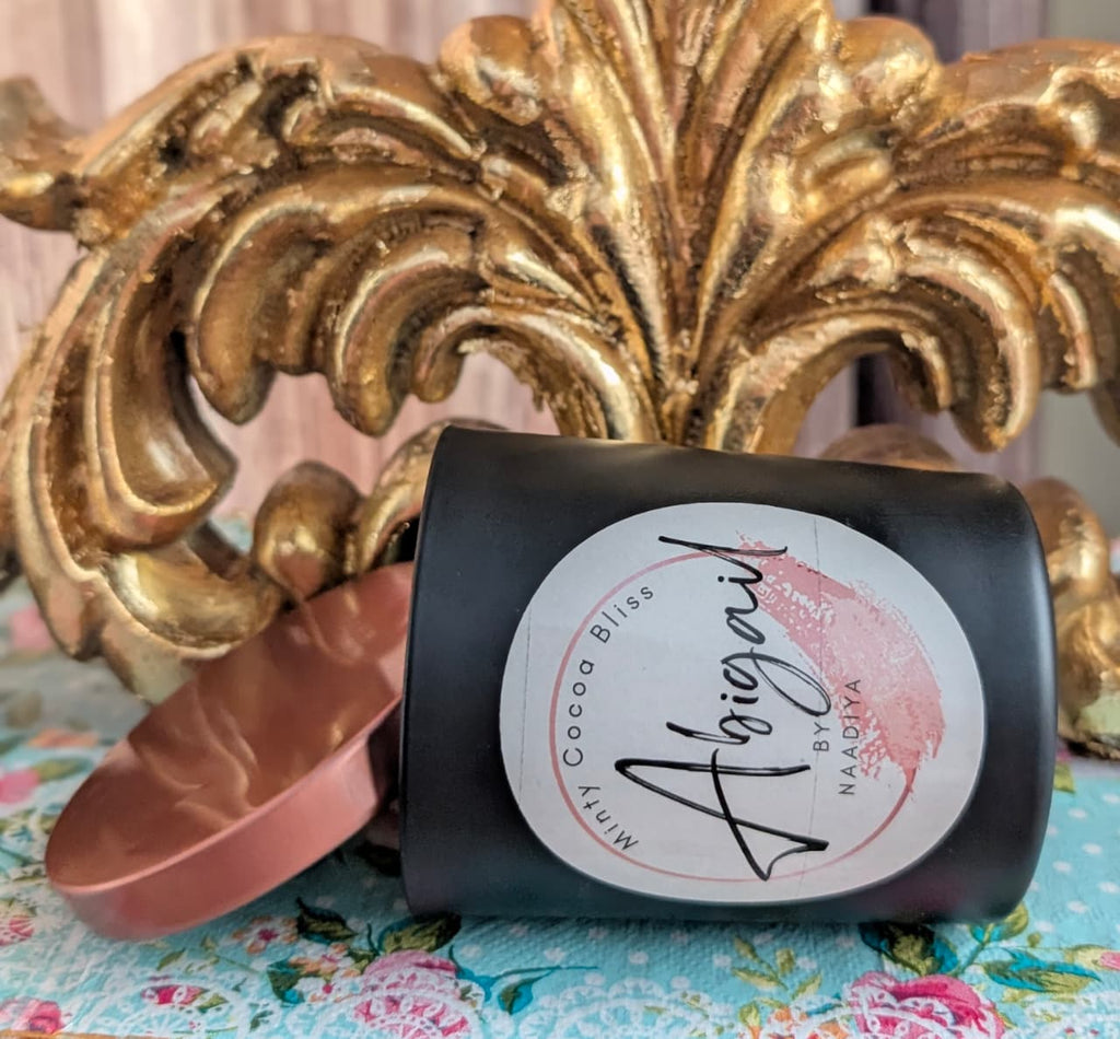 Candle with a decorative label on a floral fabric background